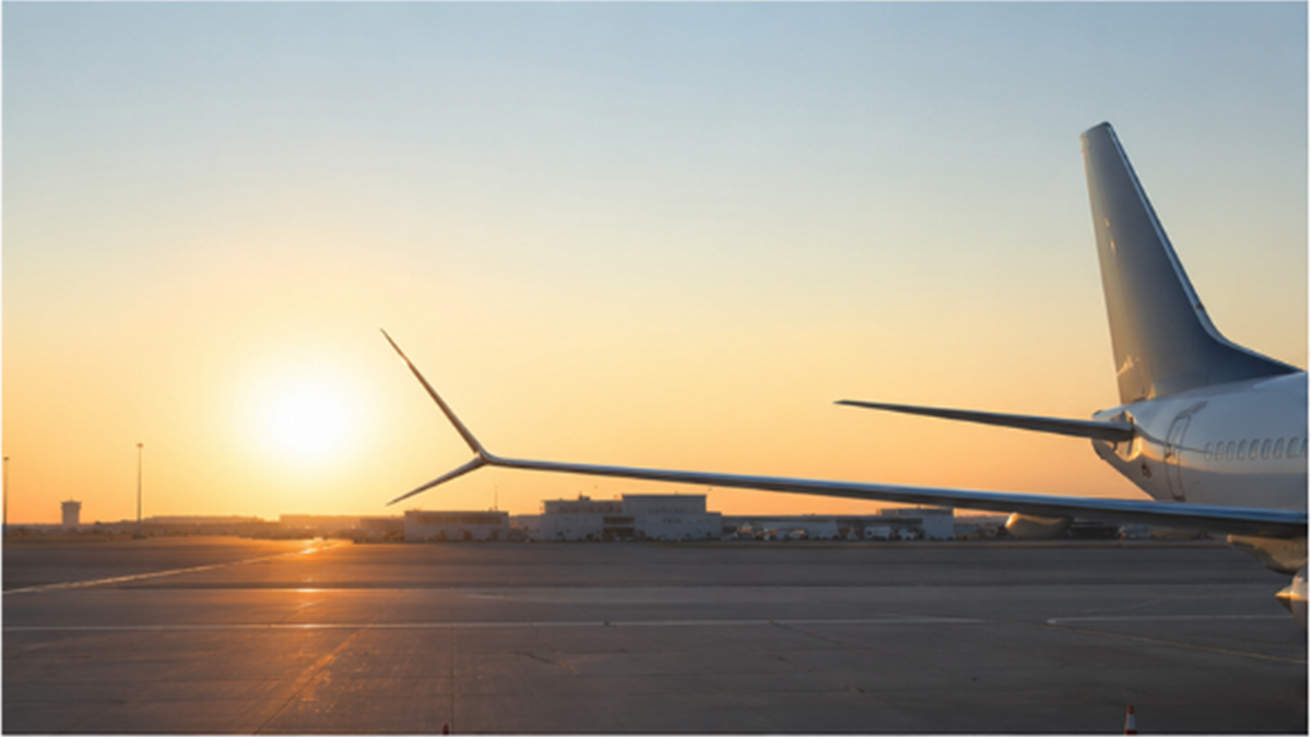 Passenger aircraft waiting on a quiet runway at sunrise