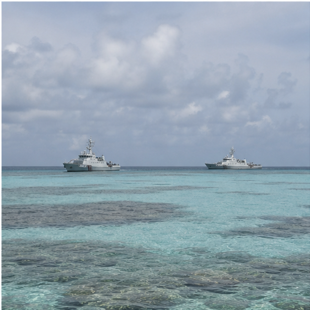 Two unmarked patrol vessels near a shallow tropical reef